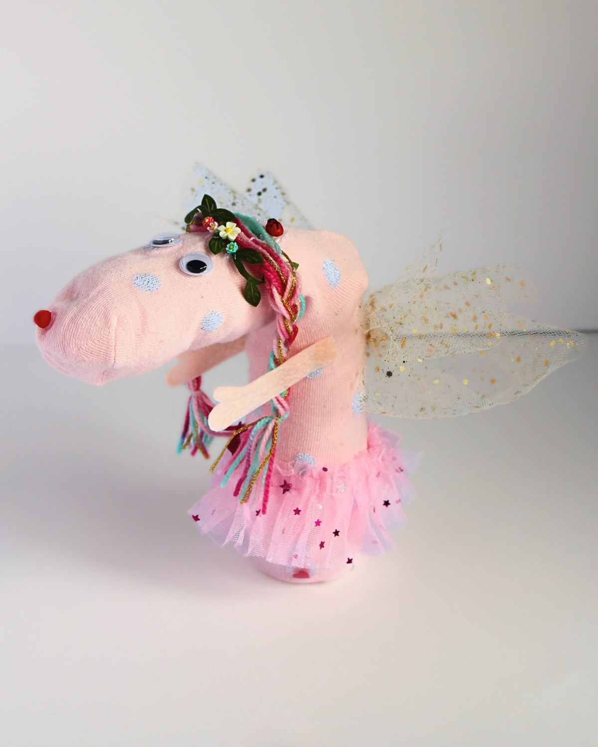 Cheeky the Fairy handmade sock puppet side view with pink tutu, gold glitter wings, felt arms and colourful braided hair