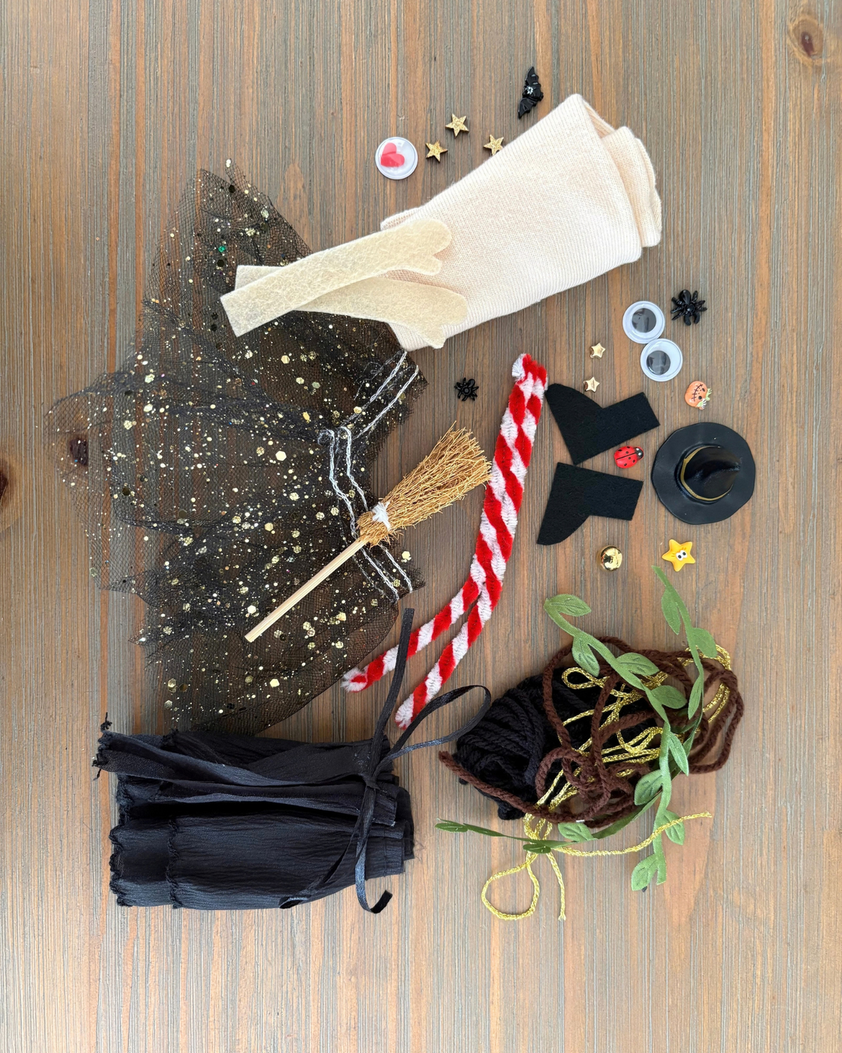 Punky witch kit materials laid out, including a sock, witch hat, broomstick, cape, tutu and craft decorations