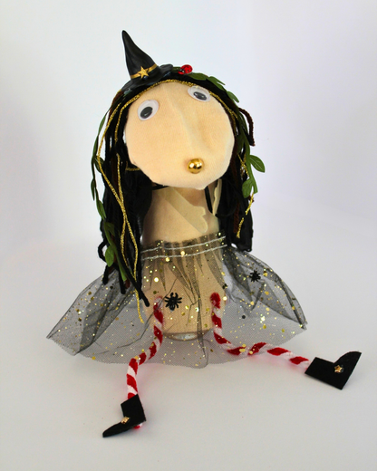 Finished Punky witch sock puppet wearing a black witch hat and glittery tutu, with a gold nose and striped legs