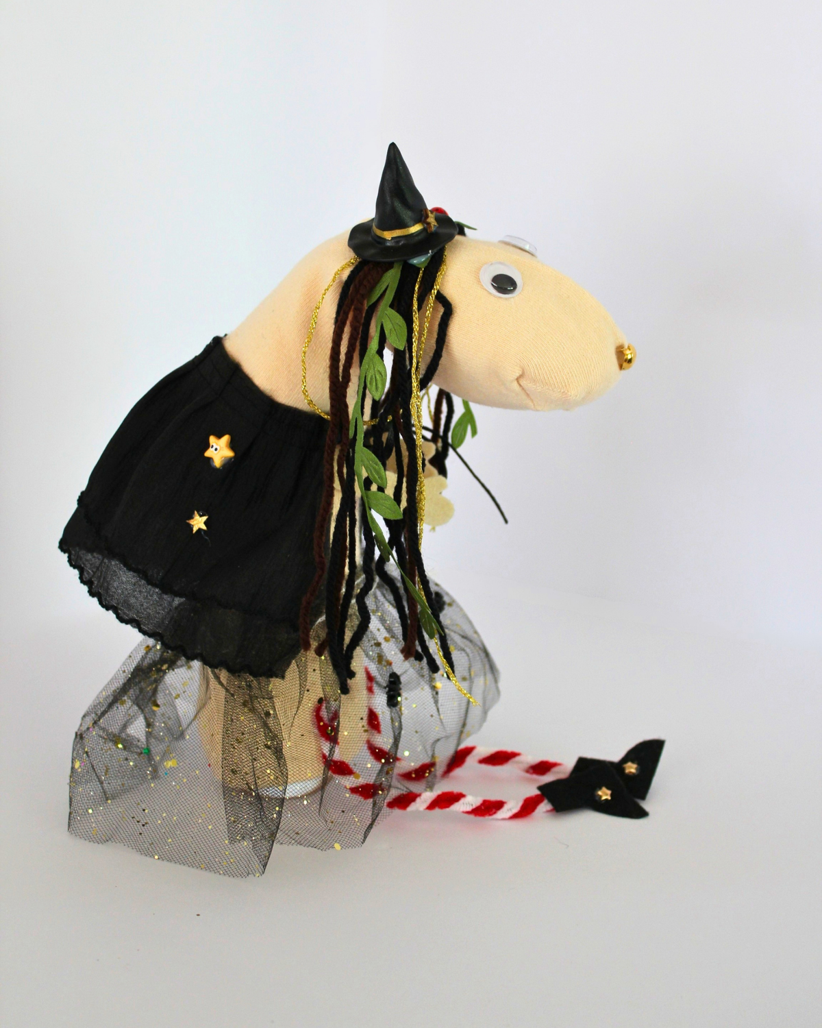 Side view of Punky witch sock puppet showing star decorations on her black cape and felt boots